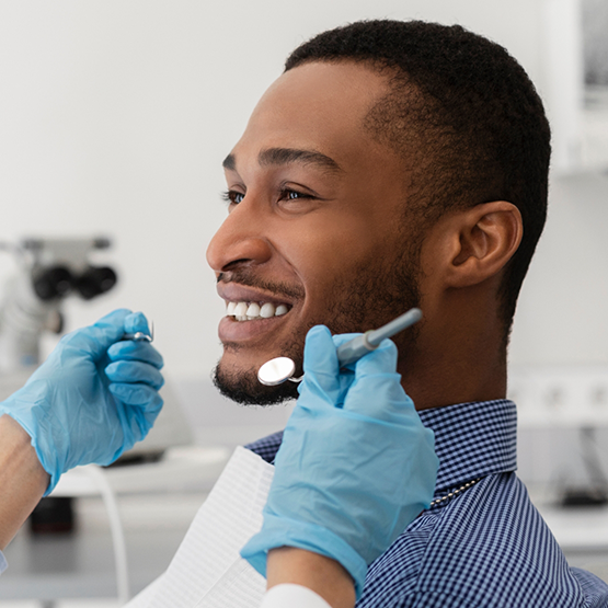 Man smiling at his dentist during a dental checkup in Tallahassee