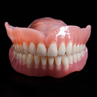 Set of full dentures against a black background