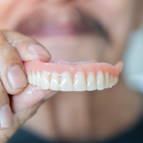 Man holding a full denture