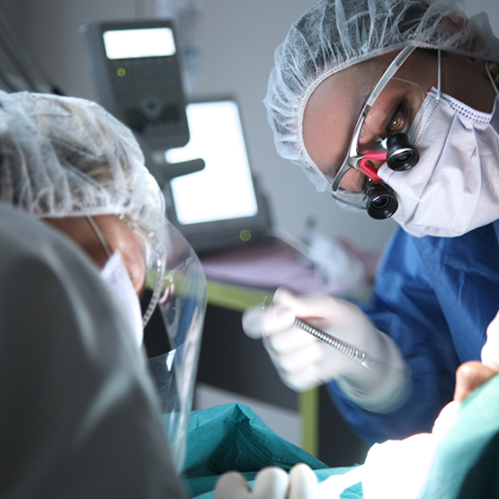 Dentist and assistant performing gum disease treatment on a patient