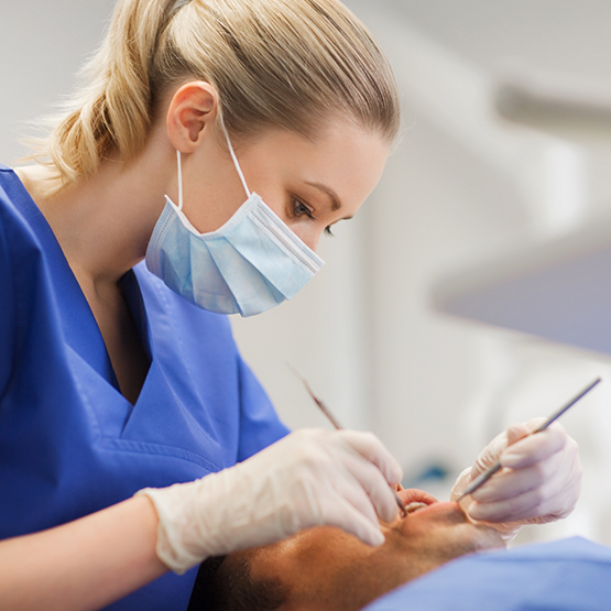 Dentist performing an oral cancer screening on a patient