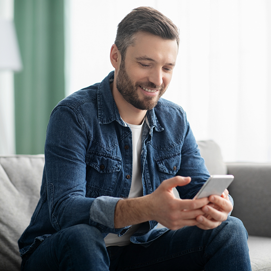 Man smiling while looking at his phone